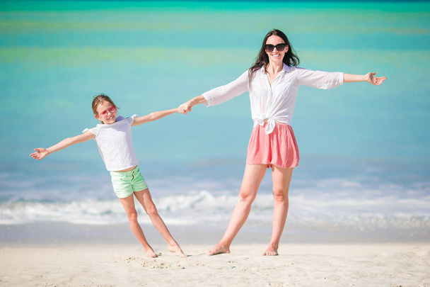Beautiful mother and daughter on Caribbean beach. Family beach vacation - Foto, immagini