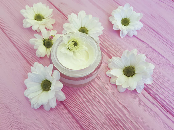 bir pembe ahşap üzerinde kozmetik krem beyaz çiçekler - Fotoğraf, Görsel
