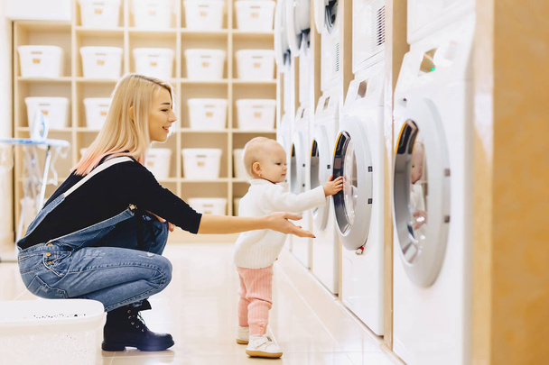 Мами і дитини в пральні приймати речі і грати - Фото, зображення