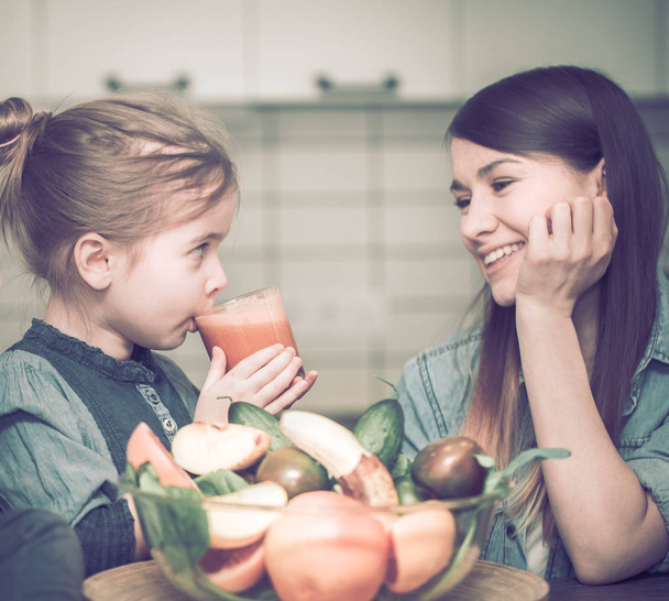 Anya a konyhában gyerekekkel készít friss gyümölcslé - Fotó, kép