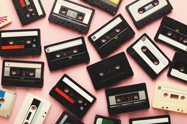 Hoop van vintage audio cassettes op roze achtergrond - Foto, afbeelding