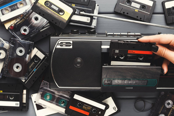 Heap of vintage audio cassettes and tape recorder at gray background - Photo, Image