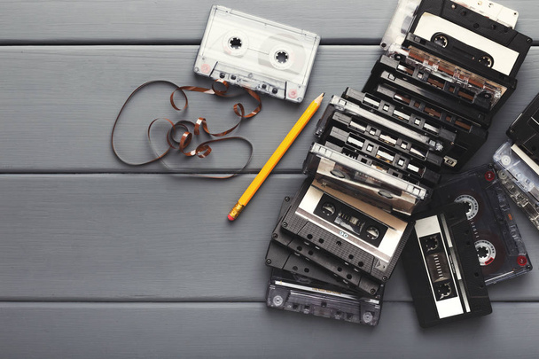 Vintage kaset ve kalem gri ahşap zemin üzerine teyp geri sarmak için - Fotoğraf, Görsel