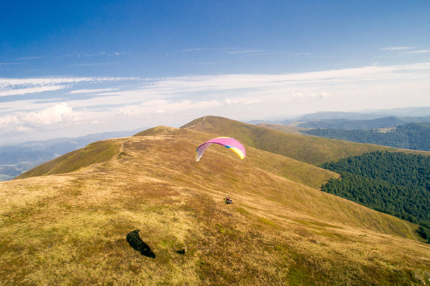 山で飛んでいるパラグライダー - 写真・画像