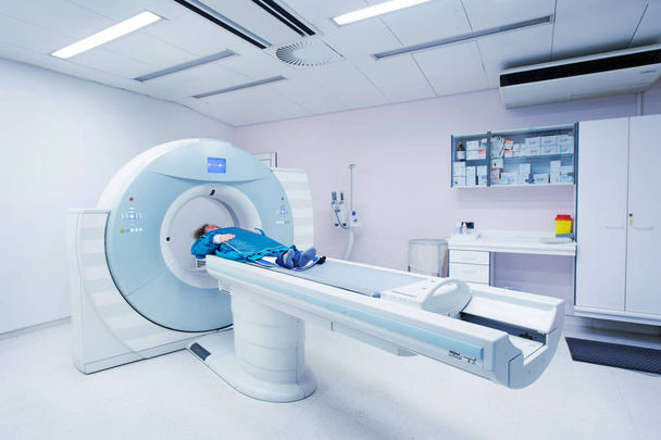 Vrouwelijke patiënt ondergaat, Ct - gecomputeriseerde tomografie Scan in het ziekenhuis. Patiënt dragen lood schort ter dekking van de vitale organen. - Foto, afbeelding