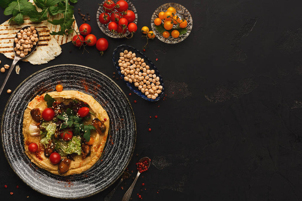 Хумус с овощами и морепродуктами на черном фоне
 - Фото, изображение