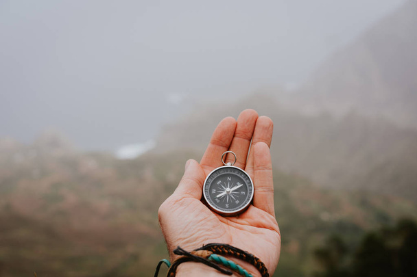 Looking at the compass to figure out right direction. Foggy valley and mountains in background. Santo Antao. Cape Cabo Verde - Fotó, kép