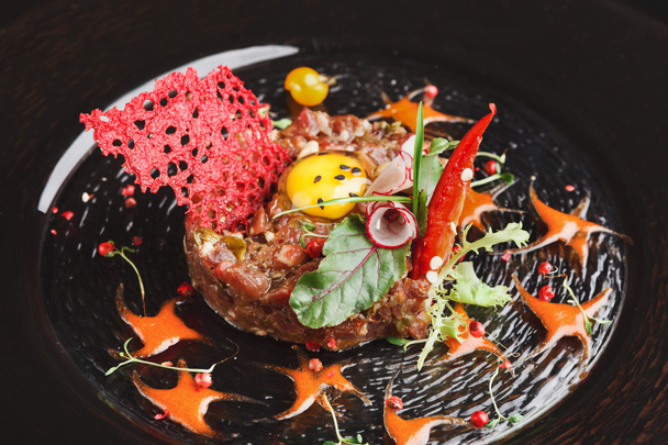 Modern restaurant dish. Veal tartare with quail egg closeup - Foto, imagen