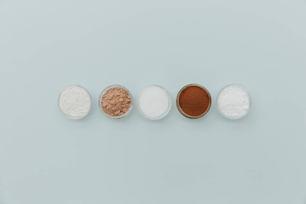 Baking soda, powder, cocoa, sugar, flour, yeast on cup for baking on pastel background. Minimal Flat lay  - Fotoğraf, Görsel
