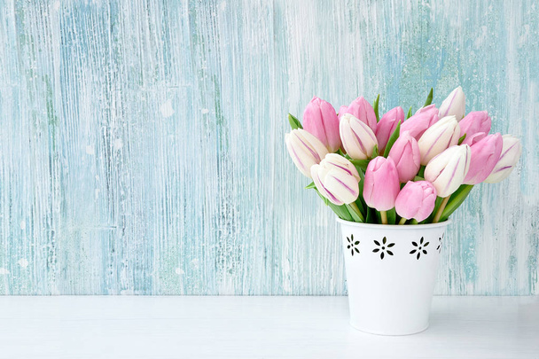 Pink tulips bouquet in white vase on light blue background. Holiday background, copy space. Valentine Day, Mothers day, birthday concept. - Photo, Image