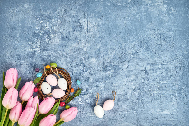 Πασχαλινό στεφάνι, Ροζ τουλίπες και διακοσμητικά Πασχαλινά αυγά σε μπλε φόντο. Το Top view, αντίγραφο χώρου - Φωτογραφία, εικόνα