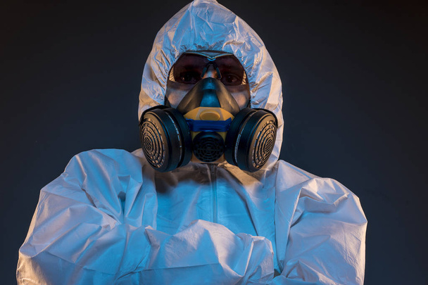 virus infection concept. Man in protective suit and antigas mask with glasses. Ebola, toxic gases, biological warfare, infections and diseases - 写真・画像