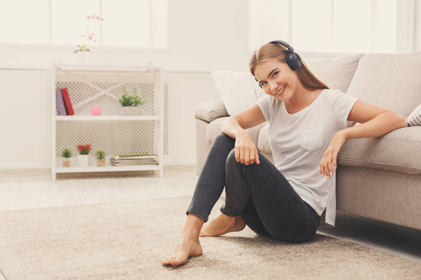 Smiling girl at home listening to music at home - 写真・画像