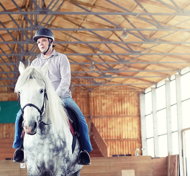 Mensen op een paard trainen in een houten arena - Foto, afbeelding