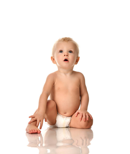 Infant child baby boy toddler sitting naked in diaper looking up  - Foto, Bild