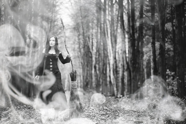 Женщина в костюме ведьмы в густом лесу
 - Фото, изображение