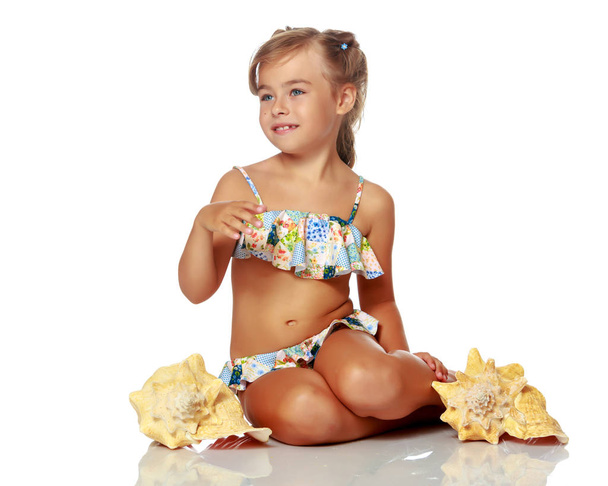Little girl in a swimsuit with a seashell - Foto, Imagem