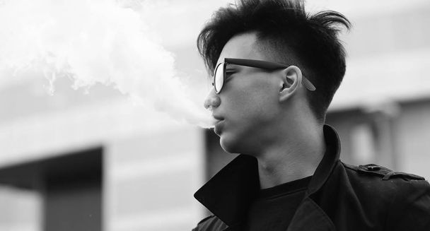 Black White photo of Asian young man outdoors posing - 写真・画像