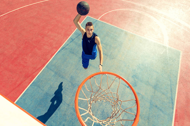 High angle view of basketball player dunking basketball in hoop - Foto, Bild