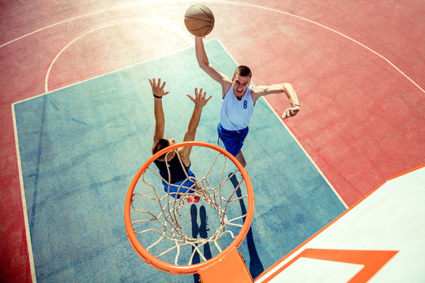 Vue grand angle du joueur de basket plongeant le basket dans le cerceau - Photo, image