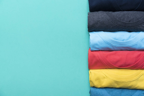 close up of rolled colorful clothes on green background - Foto, immagini