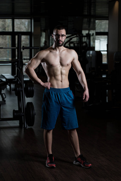 Muscular Man Flexing Muscles In Gym - Zdjęcie, obraz