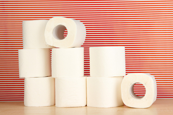 Rolls of toilet paper on striped red background - Fotó, kép