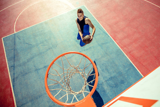 High angle view of basketball player dunking basketball in hoop - Valokuva, kuva