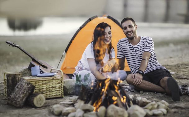 Young couple having a picnic near the lake - Фото, изображение