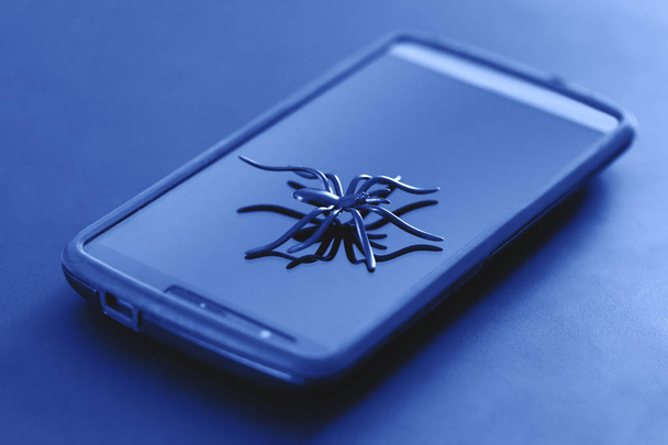 Πλαστικό αράχνη παιχνίδι σε δράση του τρεξίματος στην επιφάνεια των κυττάρων οθόνης. Μεγάλη αράχνη παιχνίδι που παρουσιάζουν στην επιφάνεια του smartphone. Πλαστικό αράχνη μοντέλο στη γυάλινη επιφάνεια του iphone - έννοια που σχετίζονται με ιδέα. Μεγάλη εικόνα για το web & έννοια ψηφιακής επικοινωνίας. - Φωτογραφία, εικόνα