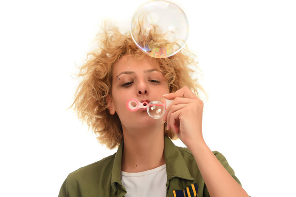 Mujer rubia atractiva haciendo burbujas de jabón. aislado sobre fondo blanco
 - Foto, Imagen