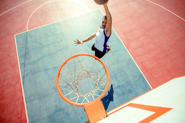 High angle view of basketball player dunking basketball in hoop - Photo, image