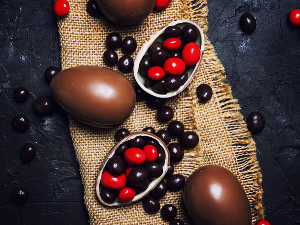 Easter composition with chocolate eggs and sweets, dark background, top view - Fotografie, Obrázek