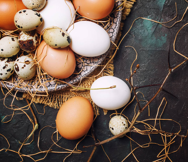 Çok renkli tavuk ve Bıldırcın yumurta saman ve dalları, Bahar Easter kompozisyon, siyah arka plan, üstten görünüm - Fotoğraf, Görsel