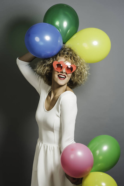 Happy funny blonde woman holding balloons - Foto, afbeelding