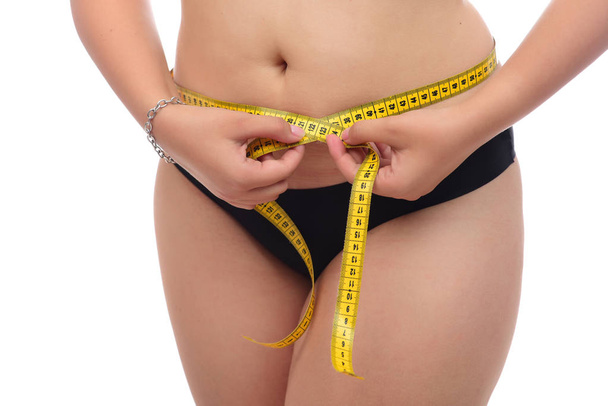 ylipainoinen nainen, jolla on valkoisella pohjalla mittanauha
 - Valokuva, kuva