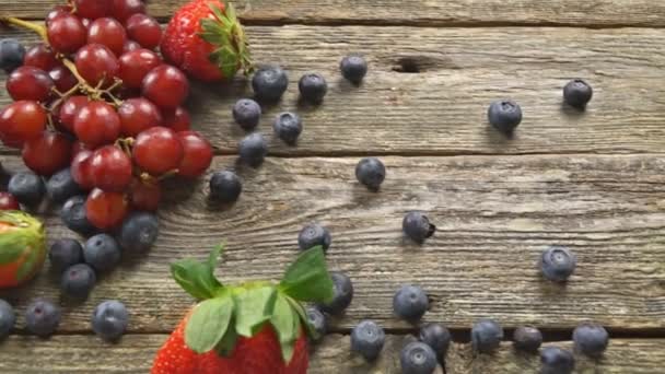 Grape jahody borůvky s dřevěnými na dřevěný stůl zpomalené hd video - Záběry, video