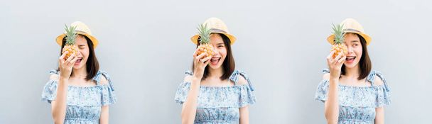 Young girl happy smile and cheerful in blue dress and hold pineapple in hand. Concept summer travel. - Foto, immagini