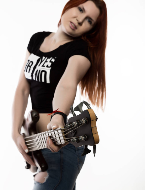 rock woman playing on electric guitar on a white background. - Foto, afbeelding