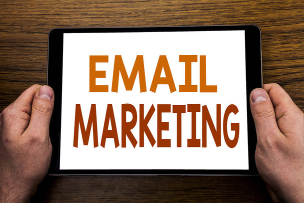 Ручной текст подпись Email маркетинг. Бизнес-концепция для онлайн-продвижения Web на планшетном ноутбуке, деревянный фон с рукой бизнесмена, держащий палец ПК
. - Фото, изображение