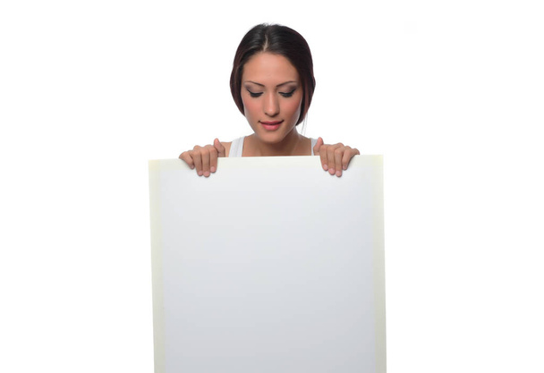 Portrait of young beautiful woman holding white blank sheet. Isolated on white background - Foto, Imagem