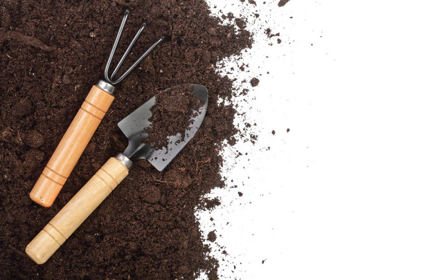 garden tools in soil isolated on white background with copy space for your text. Top view - Foto, imagen