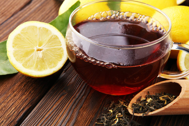 Sklo šálek horkého čaje s citronem na hnědé dřevěné pozadí. - Fotografie, Obrázek