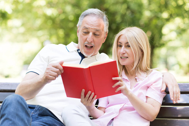 Mature couple reading a book in the park - Foto, Imagem