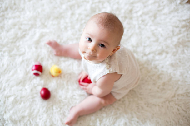 Χαριτωμένο μικρό παιδί μωρό αγόρι, παίζοντας με πολύχρωμα Πασχαλινά αυγά  - Φωτογραφία, εικόνα