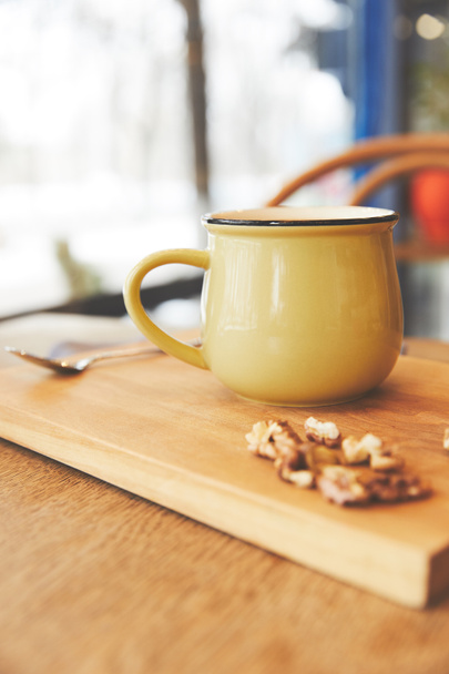 Cacao caliente en taza con nueces servidas sobre tabla de madera
 - Foto, imagen
