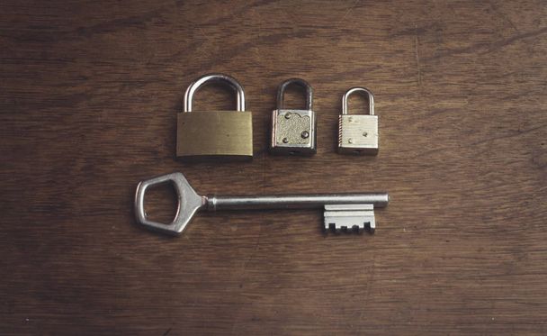 three different padlock and one big key - Photo, Image
