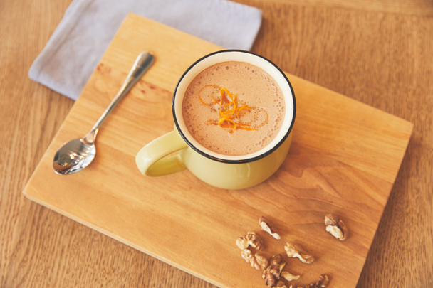 Warme chocoladedrank met sinaasappelschillen dienen in café - Foto, afbeelding