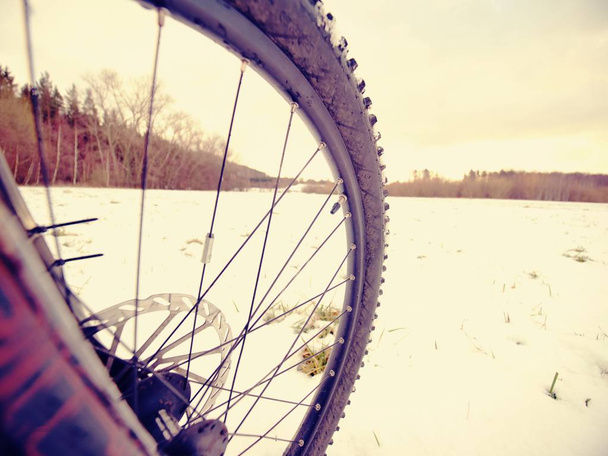 Winter snow riding on mountine bike. Extreme weather, slippery road in field, close  view - Photo, Image
