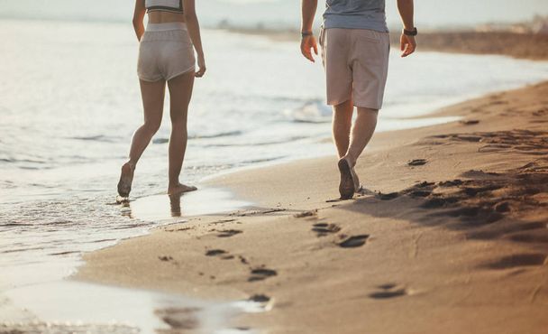 Casal caminhando na praia juntos
 - Foto, Imagem